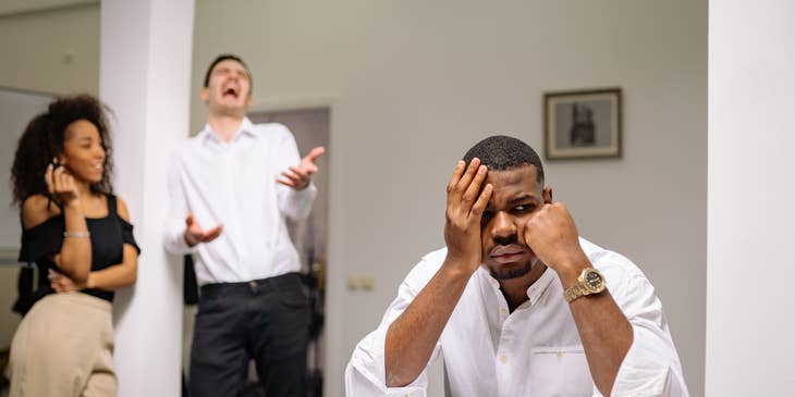 An employee experiencing workplace harassment from their colleagues in an office setting.