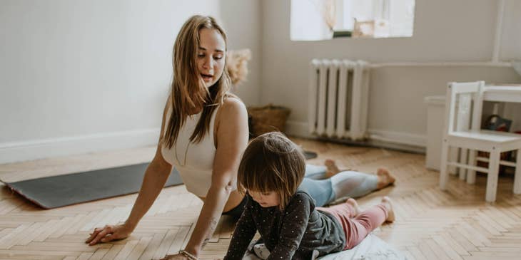 Childcare Teacher playing yoga with a toddler