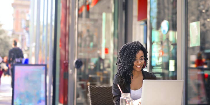 Freelance Writer happily reads her new content while sipping a cold tea