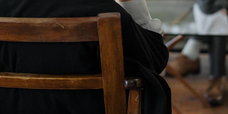 Mediator holding her eyeglasses as she listens to the client's conflict