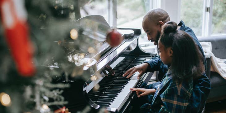 Music teacher teaches a student in playing piano for a Christmas play