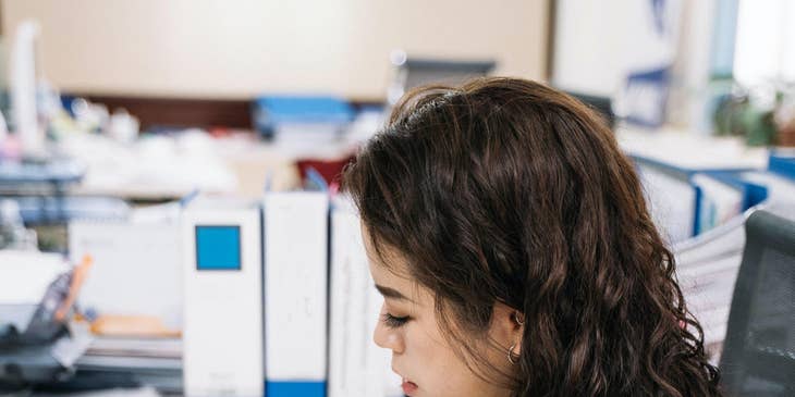 Payroll coordinator verifying employee data while making calls about payroll concerns