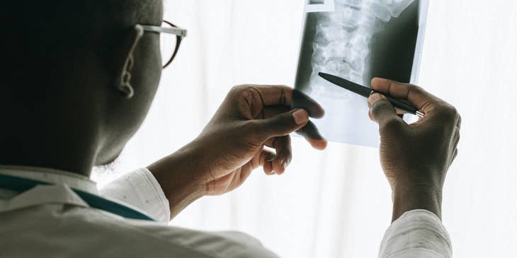 Physiatrist examines Xray results to determine treatment plans for patient
