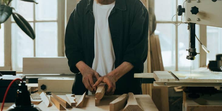 Product designer working on a new project while checking his wood designs.