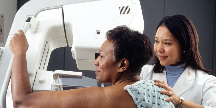 Radiologic technologist position patient for a mammogram procedure while explaining the procedure