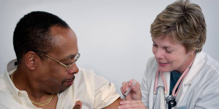Registered nurse gives a patient a flu shot while giving instructions on aftercare