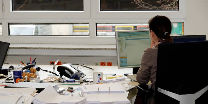 Revenue Cycle Manager checks emails while preparing billing documents for the meeting