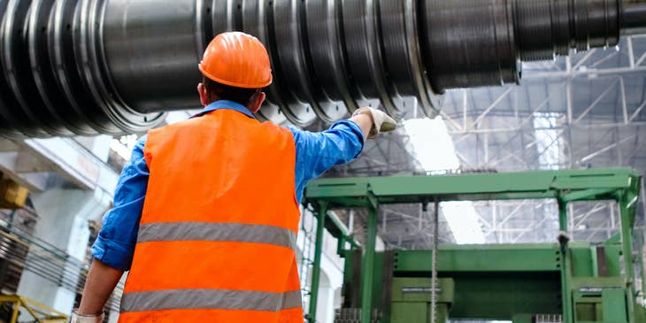 Safety coordinator checks the machine in a workplace to ensure safety in the workplace