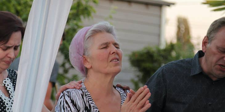 Spiritual healer prays with a woman during a healing service