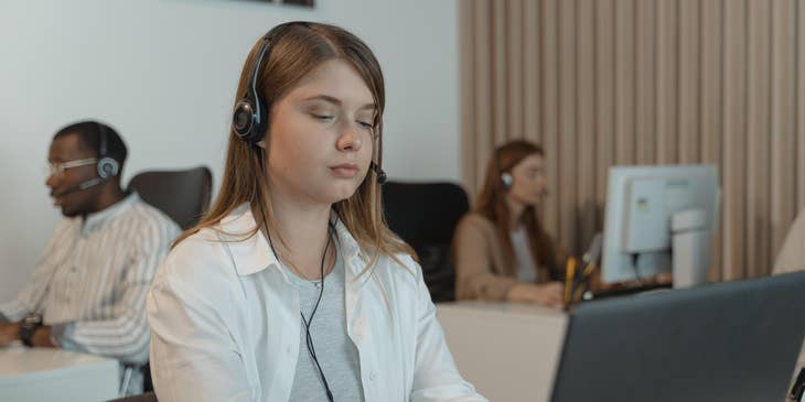 Support Specialist talks to a coworker in resolving IT issues over the phone