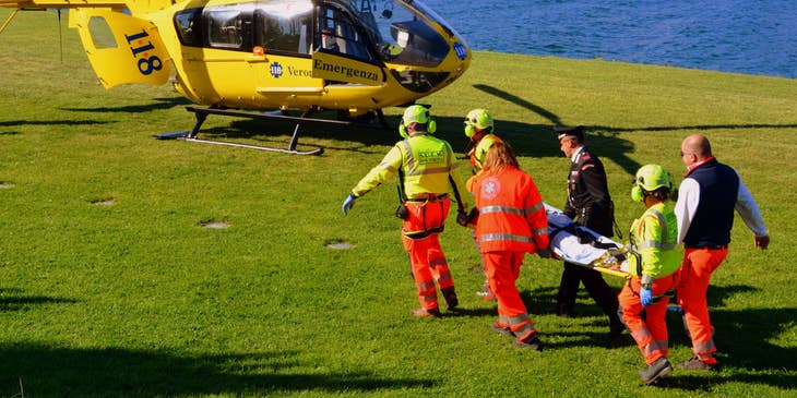 Travel nurse helps an injured patient in a stretcher to the chopper to the hospital for treatment