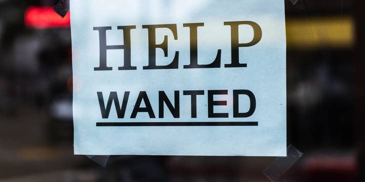A "help wanted" sign behind glass.