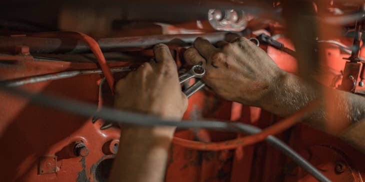 Aircraft Mechanic holding a red motor frame and wrenches in both hands