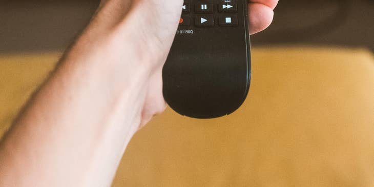 Appliance Repair Technician checking if a tv is working using a remote