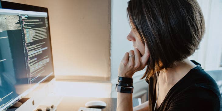 APS.NET Developer looking at her monitor while sitting on her workstation