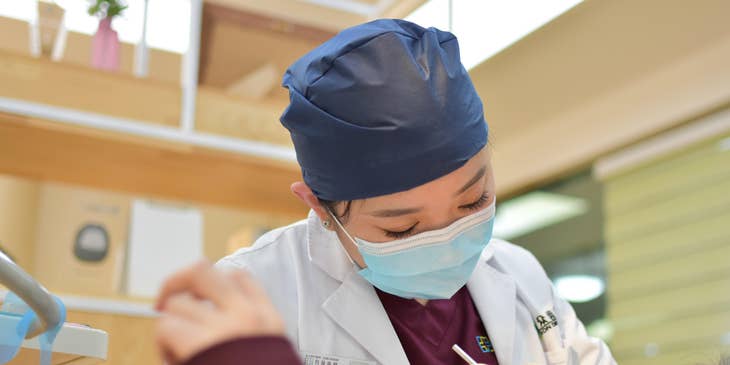 The associate dentist examining patients' teeth and gums.