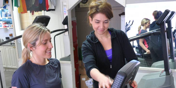 Athletic Trainer next to a woman in a cycling machine