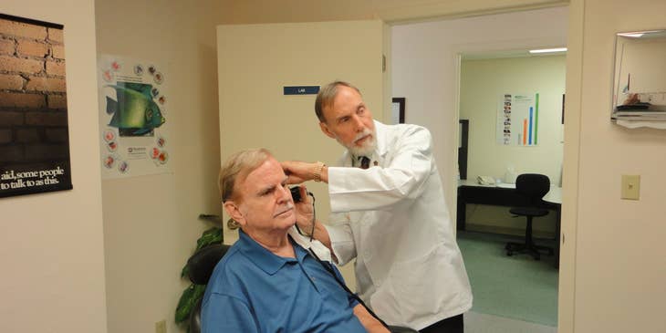 Audiologist conducting auditory test on patient.