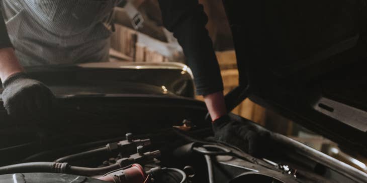 Auto Electrician checking under the hood of a vehicle
