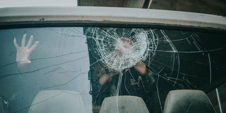 Auto Glass Technician checking a cracked rear window of a car