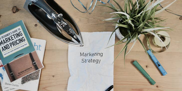 Una hoja de papel con la frase “Estrategia de marketing”, escrita en inglés, en una bolsa de trabajo para marketing.