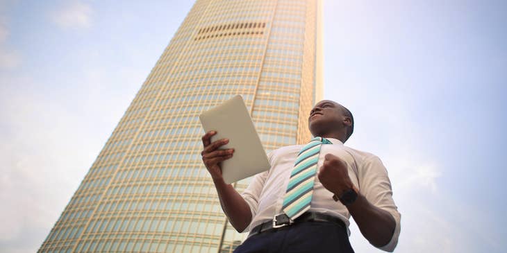 Business analyst celebrating near a building