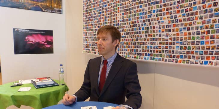 A business professional sitting at table at a career fair.