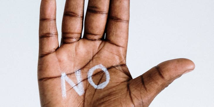 Una mano con la palabra "No" escrita en su palma.