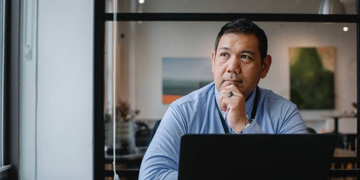 A chief security officer in thought working at a desk.