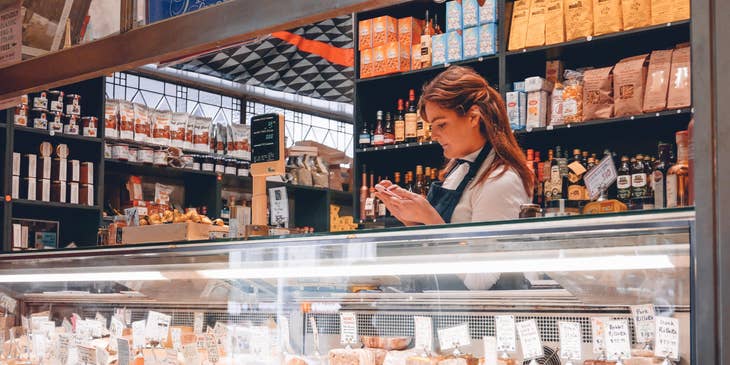 A counter attendant serving food behind a counter.