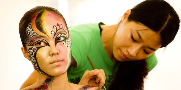 A film makeup artist applying makeup to an actress on a movie set.