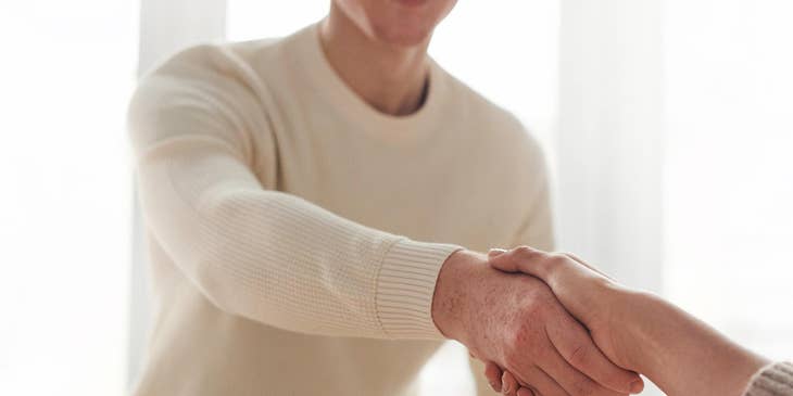 man shaking hand of woman