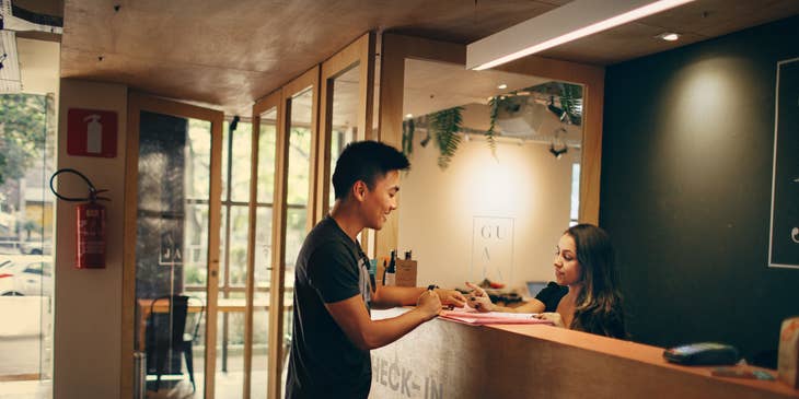 A front desk manager talking to a customer.