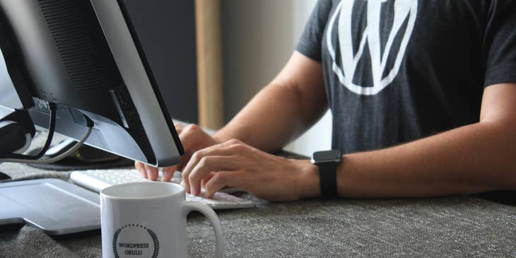 Person working on a computer wearing WordPress t-shirt.