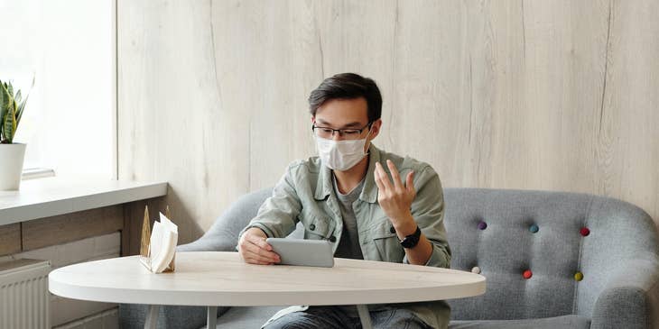 man wearing a mask in restaurant discussing a layoff letter due to COVID-19.