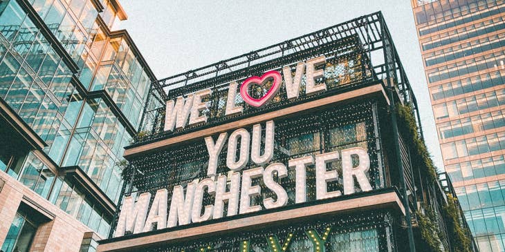 A view of a building in Manchester with a sign that says, "we love you Manchester."