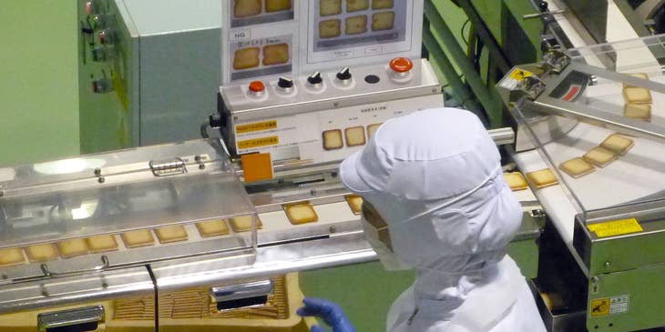 A packaging machine operator at work in a cookie factory.