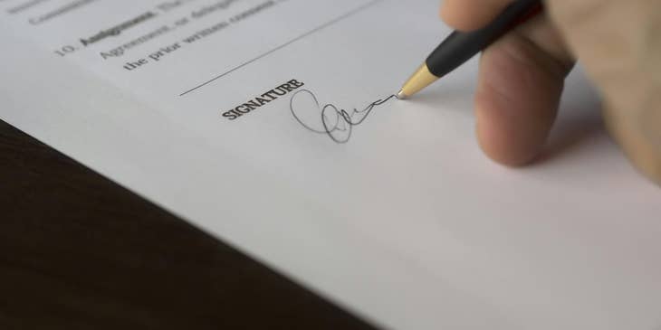 Una persona firmando la política de conflicto de interés de un negocio.