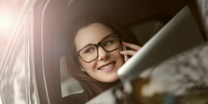 Una mujer en el vehículo de la empresa hablando por el celular.