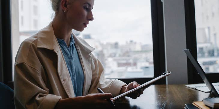 A secretary assistant reading a report in her office.