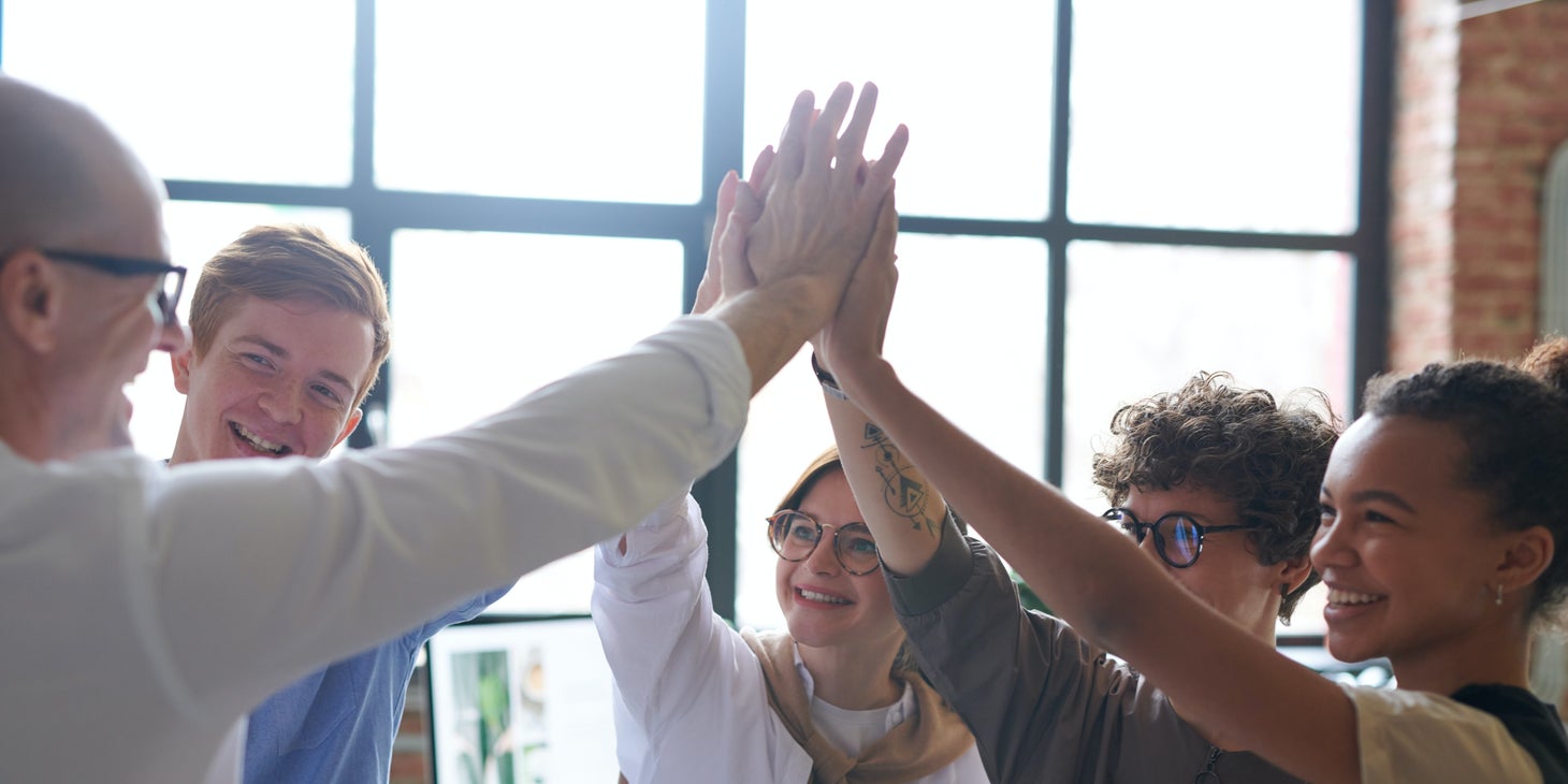 Des personnes unissent leurs mains lors d'une activité team building.