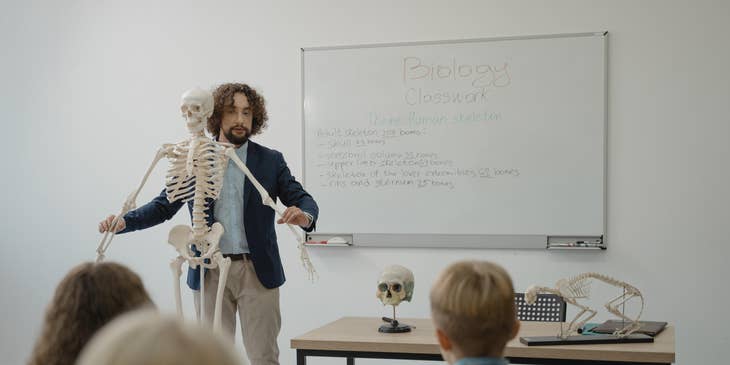 Biology Teacher explaining human anatomy to his students in a classroom