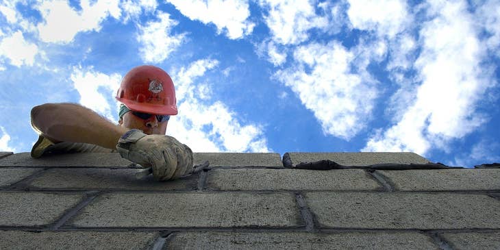 Bricklayer carefully laying bricks for a commercial building.