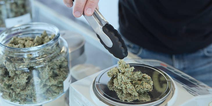 Budtender weighing customers order before packing