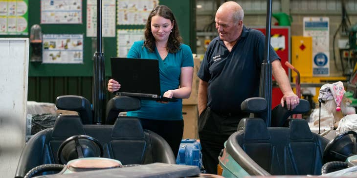 CAD Operator showing new draft plans to her manager in a workshop
