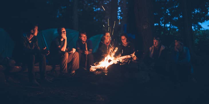 a group of campers around a campfire