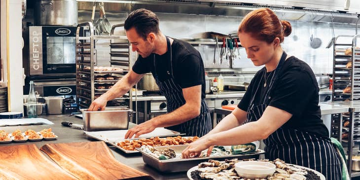 Catering Assistant helps in the food preparation.