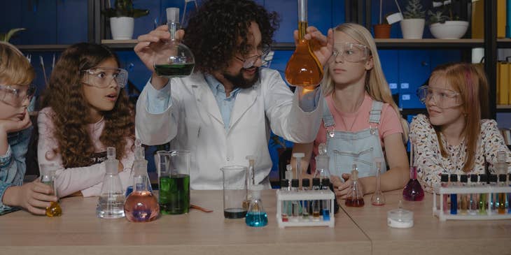 Chemistry Teacher explains different chemicals to his students in a laboratory