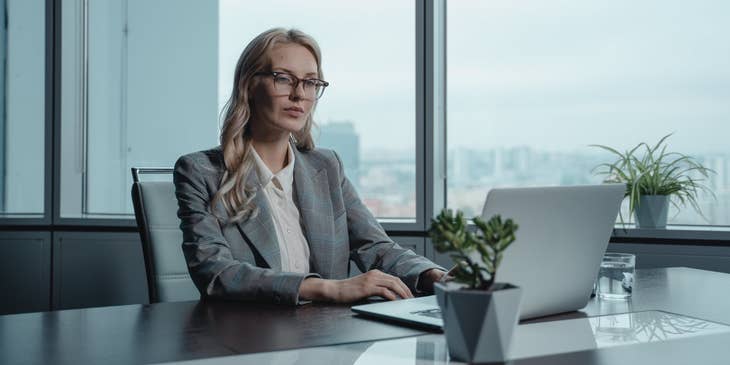 female CIO wearing eyeglasses and typing on her laptop