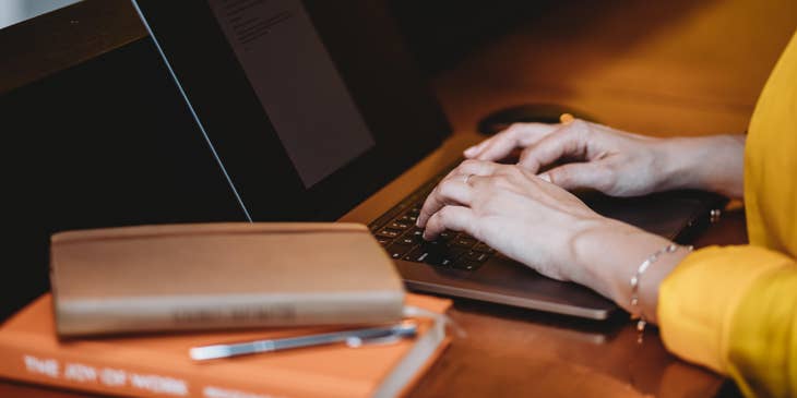 A Female Claims Specialist sitting in front of her laptop with a journal on the side of her desk.